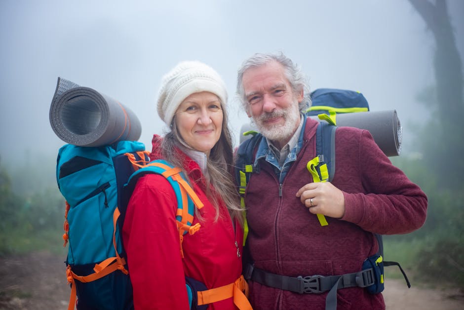 Senior couple hiking together in foggy scenery in Portugal, showcasing adventure and companionship.